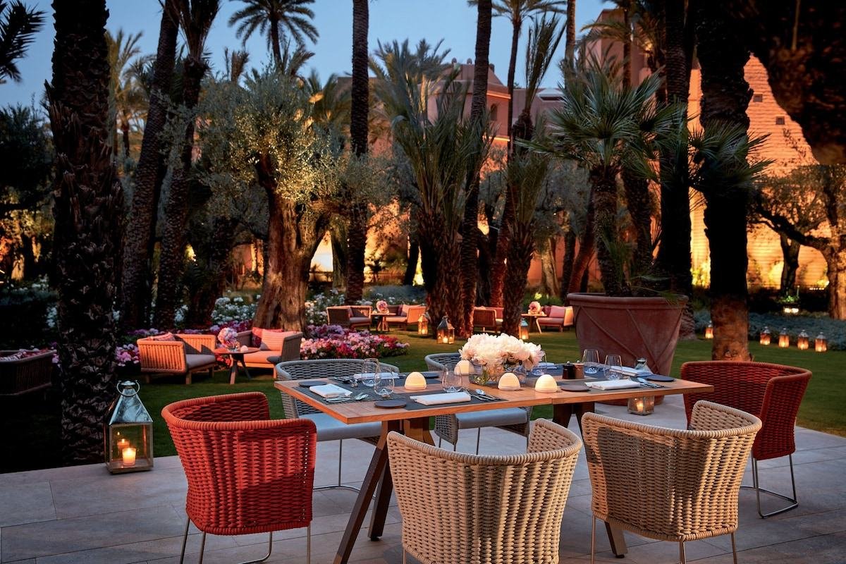 Candlelit dinner table in the gardens of a palace hotel in Marrakech